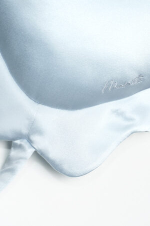 Close-up of MANITO whale-shaped pillow's embroidered eye and fin details, emphasizing craftsmanship.