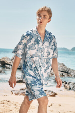 A man walks along the beach wearing MANITO Ocean Blue Men's Short Pajama Set, featuring a breezy floral print.