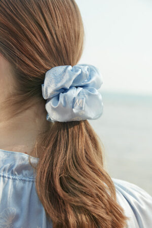 Model wearing the blue silk scrunchie from MANITO Ocean Blue Sleeping Beauty Gift Box, showing marine pattern.
