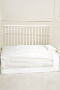 MANITO Ocean Stripe baby crib bedding set displayed in a white crib.