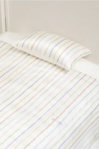 Close-up of MANITO Ocean Stripe baby crib bedding set with a silk pillowcase.