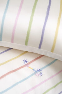Embroidery detail on the MANITO Ocean Stripe baby crib bedding set, featuring a delicate sun and wave motif.