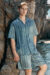 Man wearing MANITO Ocean Stripe Men's Short Pajama Set by the rocks, showcasing the relaxed beachwear style.
