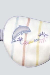 Showcasing a dolphin and sun embroidery, adding a playful yet elegant touch to the premium silk sleep accessory.