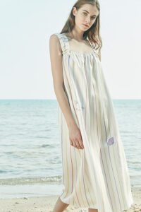 A front view of MANITO rainbow stripe dress, featuring thick straps and delicate embroidery of a dolphin and seashell.