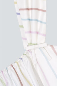 Zoomed-in view of the thick strap with a decorative bow on the MANITO rainbow stripe dress.