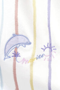 Close-up of the dolphin embroidery on the MANITO tank top, adding a playful touch.