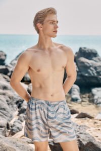 MANITO Ocean Wave Men's Shorts styled in a beach setting with a relaxed fit and wave pattern.