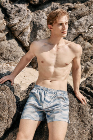 Side view of MANITO Ocean Wave Men's Shorts with natural sunlight highlighting the silk texture.