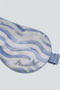 Close-up detail of the MANITO logo and wave pattern on the silk eye mask.