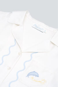 Close-up of collar and dolphin-embroidered pocket on the MANITO Ocean Wave Silk Women's Short Pajama Set.