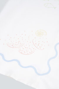 Zoomed-in view of shell and sand pattern on the MANITO Ocean Wave Silk Women's Short Pajama Set.