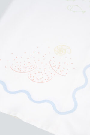 Zoomed-in view of shell and sand pattern on the MANITO Ocean Wave Silk Women's Short Pajama Set.