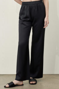 Model showcasing MANITO Passion Women's Silk Trousers in classic black, styled with black sandals.