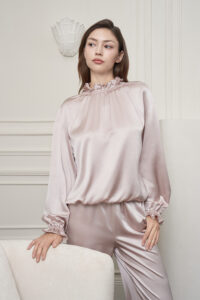 Model wears the Purity Silk Women's Drawstring Set, highlighting the soft lotus-pink silk top with delicate ruffle neckline.