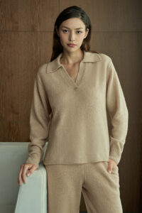 Woman in beige Purity Polo Knit Set stands with natural poise, showing the relaxed drape and timeless minimalist charm.