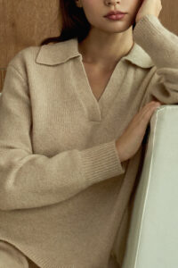 Close-up of woman wearing beige Purity Polo Knit Set, highlighting its soft texture and refined polo collar.