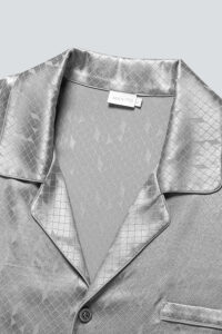 Fabric detail of MANITO Fragment Men's Pajama Set showing diamond jacquard silk collar and button.