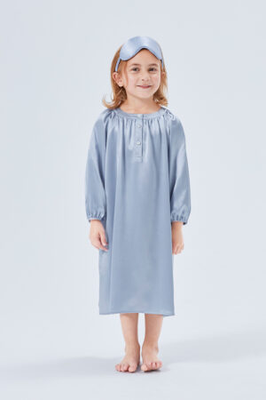 Cheerful young girl with matching silk sleep mask and crystal blue silk sleep dress.