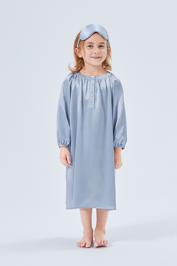 Cheerful young girl with matching silk sleep mask and crystal blue silk sleep dress.
