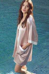 Fashionable woman in a pool wearing Whisper Women's Short Silk Kimono in pink with stylish cut.