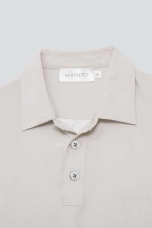 Close-up of Remington Short Sleeve Lounge Shirt's collar detailing MANITO logo and high-quality button craftsmanship.