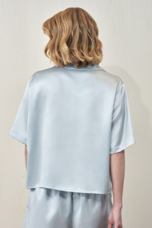 Back view of MANITO Remington Women's Silk Short Pajama Set in light blue worn by model.