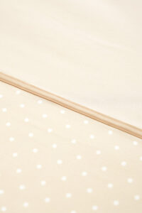 Detailed view of the MANITO silk duvet cover's fabric, highlighting the subtle polka dot pattern and premium stitching.