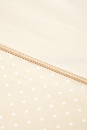 Detailed view of the MANITO silk duvet cover's fabric, highlighting the subtle polka dot pattern and premium stitching.