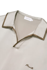 Close-up of MANITO Ribbon Men's Polo Silk Pajama Set showing contrast piping on collar and embroidered logo.