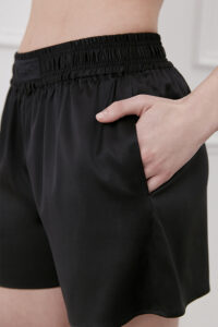 Side view of Passion Women's Silk Shorts in black highlighting pocket and gathered waist.
