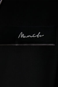 A close-up of the MANITO logo on Rome Men's Black Silk Robe.