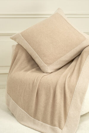 Sand Dune Knit Pillow placed on a matching sand-toned throw, showing soft texture and cashmere-silk blend.