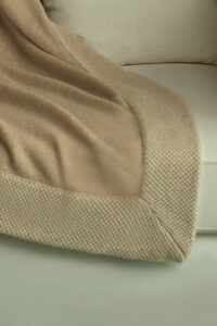 Close-up of Sand Dune Knit Throw Blanket edge, highlighting its fine knit border and cozy woven texture.