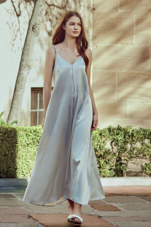 Model wearing Serene Silk Long Dress in Nimbus Cloud, strolling outdoors.