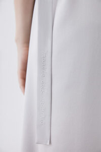 Close-up of Serene Silk Long Dress's fabric and embroidery, emphasizing the 'Manito Silk Moments' script.