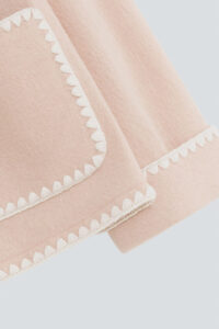 A detailed view of the scalloped edge on the cuffs of Shell Women's Cashmere Pink Lounge Top, showcasing the intricate design.