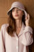 Model wears Shell Women's Silk Wool Bucket Hat in soft pink, featuring an embroidered brim and classic fisherman silhouette.
