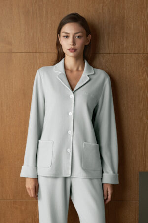 Woman wears Shell Silk Wool Pajama Set in blue, front view with relaxed straight-leg fit for calm evenings at home.