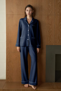 Woman in navy Shell Silk Wool Pajama Set, full-length front view with button front and patch pockets for cozy home lounging.