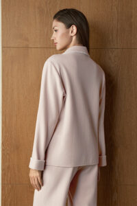 Close back view of woman in pink Shell Silk Wool Pajama Set, highlighting smooth drape and softly structured collar.