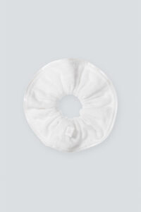 Overview of MANITO Silk Terry Scrunchie with a soft, plush texture and a subtle branded tag, displayed on a light gray background.