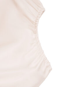 Seam detail of leg opening on MANITO Sophia Baby Romper in mulberry silk fabric.