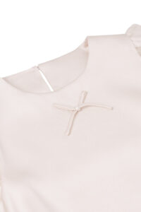 Close-up of MANITO Sophia Baby Sleeveless Romper with delicate silk bow on the chest.
