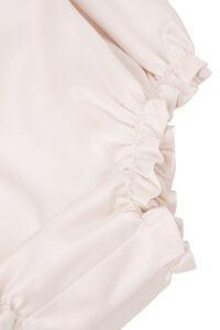 Bottom hem detail with elastic gathering on MANITO Sophia Baby Sleeveless Romper.