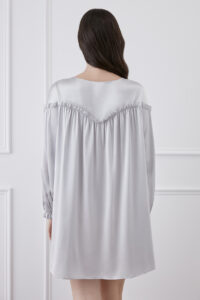 Back view of woman wearing silver gray silk mini dress, providing an overview of the dress.