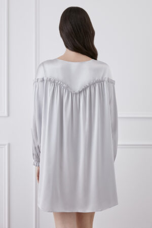 Back view of woman wearing silver gray silk mini dress, providing an overview of the dress.