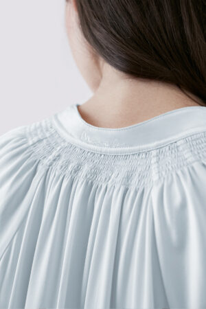 Close-up of MANITO logo embroidery detail on back of Sophia midi dress, showcasing intricate craftsmanship.