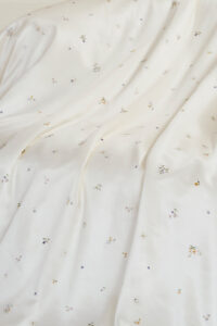 Sweet Garden Silk Throw featuring soft draping silk fabric with delicate floral motifs in a smooth, elegant finish.