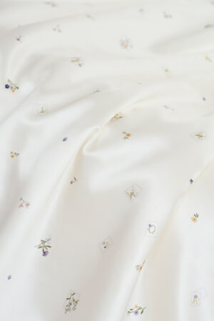 Sweet Garden Silk Throw showcasing close-up draped silk with subtle Sweet Garden floral patterns for a refined texture.